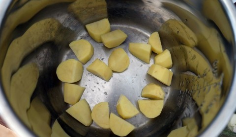patate tagliate a pezzettoni sul fondo della Slow Cooker