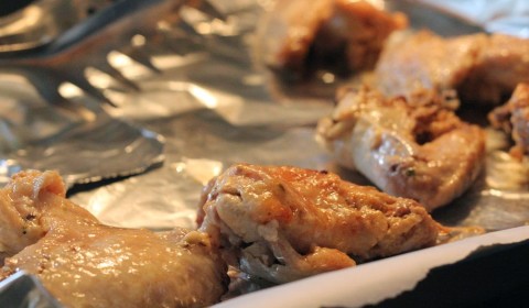 Le alette di pollo con aglio e parmigiano disposte su una teglia da forno