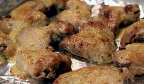 Le alette di pollo con aglio e parmigiano disposte su una teglia da forno