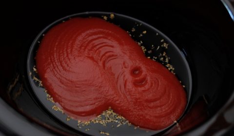 Il fondo della Slow Cooker con l'olio e la salsa di pomodoro